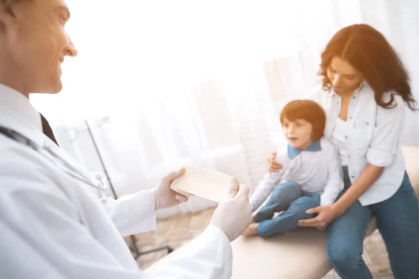 El médico con guantes blancos sostiene la venda . — Foto de Stock