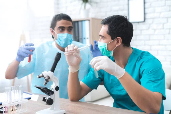 Le médecin verse du liquide d'une éprouvette à l'autre . — Photo