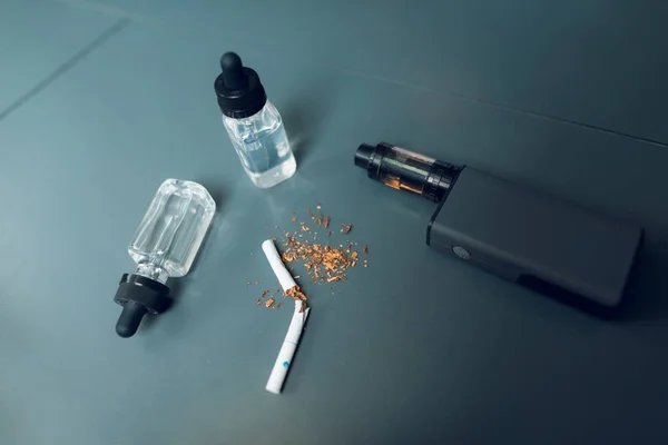 Schachtel, Flüssigkeit und eine kaputte Zigarette liegen auf dem Tisch. — Stockfoto