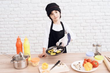 Küçük çocuk aşçı meslek mastering. Esmer çocuk bir aşçı olmak istiyor. O aşçı çalar ve akşam yemeği hazırlar.