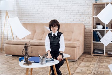 Gözlük ve takım elbise içinde küçük bir çocuk kendini bir işadamı olarak sunar. Çocuk zengin bir adam çalış. O bir sandalyede oturur, belgeleri etrafında uçuyor. O bir sandalyede oturur, belgeleri etrafında uçuyor.