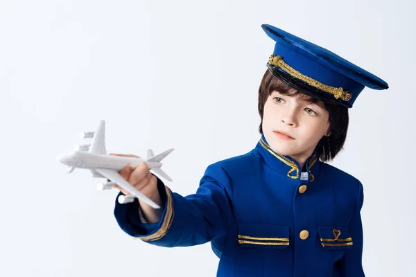 这个小男孩学习飞行员的职业 那个黑发男孩想成为一名飞行员 他在飞行员制服上玩玩具飞机 — 图库照片