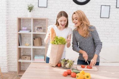 Anne ve kızı birlikte mutfakta yemek vardır. Onlar sebze yemek pişirmek için kullanın. Onlar iyi bir ruh halinde vardır. Birlikte olmak mutluyuz.