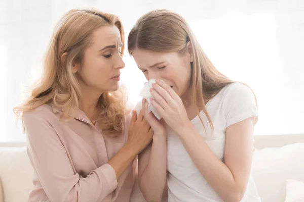 女人安慰十几岁的女儿 他们坐在家里的沙发上 这女孩有麻烦了妈妈抱着女孩 — 图库照片