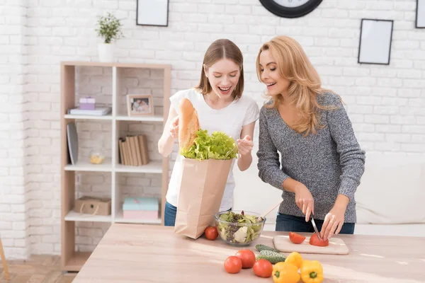 Anne ve kızı birlikte mutfakta yemek vardır. Onlar sebze yemek pişirmek için kullanın. Onlar iyi bir ruh halinde vardır. Birlikte olmak mutluyuz.