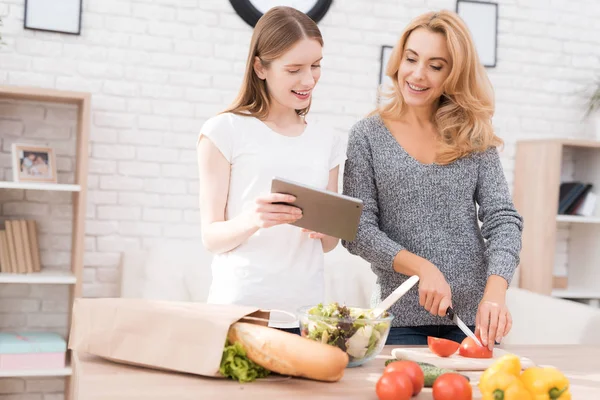 Anne ve kızı birlikte mutfakta yemek vardır. Onlar sebze yemek pişirmek için kullanın. Onlar iyi bir ruh halinde vardır. Birlikte olmak mutluyuz.