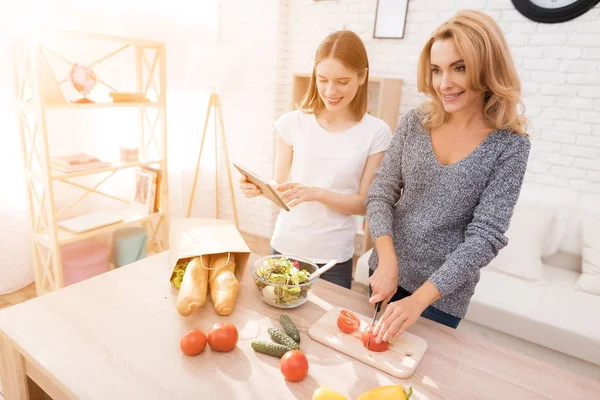 Anne ve kızı birlikte mutfakta yemek vardır. Onlar sebze yemek pişirmek için kullanın. Onlar iyi bir ruh halinde vardır. Birlikte olmak mutluyuz.