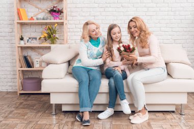 Küçük bir kız annesi ve büyükannesine bir buket lale veriyor. Anneler Günü 'nü kutluyorlar. Geleneksel bir aile tatili yapıyorlar..