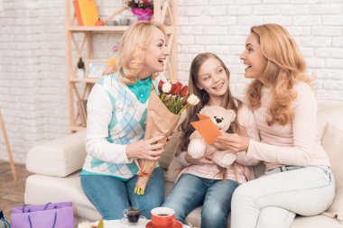 İki yetişkin kadın ve bir kız bir tebrik kartı arıyoruz. Bu annem ve büyükannem kızın. Onlar evde akşam yemeği.