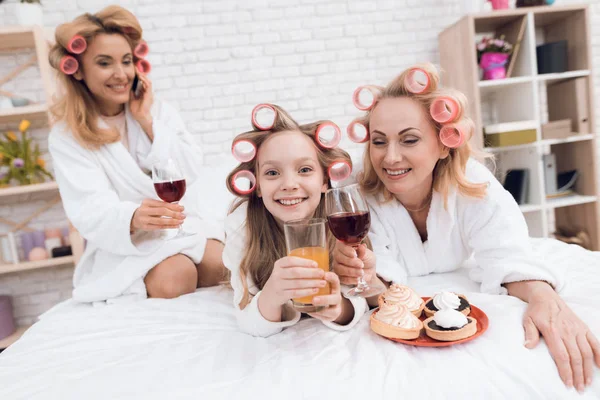 Mamma Mormor Och Flicka Papiljotter Dricka Vin Och Juice Sängen — Stockfoto