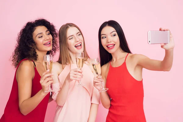 Trzy Dziewczyny Białe Czerwone Sukienki Szampana Biorąc Selfie Różowym Tle — Zdjęcie stockowe