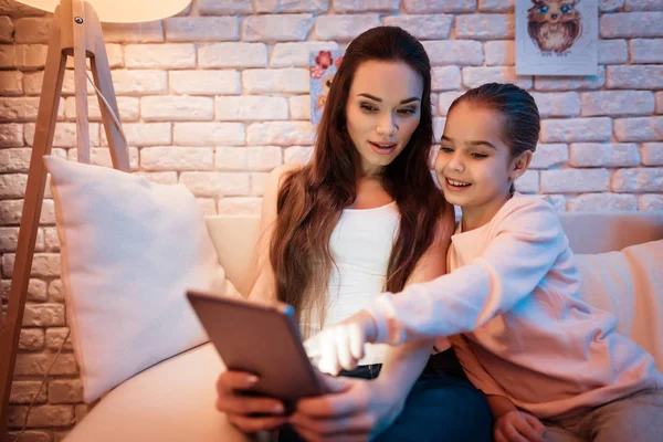 母亲和小女儿看电影在平板电脑在晚上在家 — 图库照片