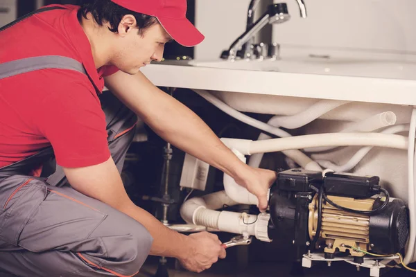 Tesisatçı boruları onarır. Erkek uzmanı tesisatçı onarım. — Stok fotoğraf