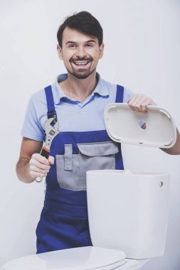 Tesisatçı bir floş tuvalet onarıyor