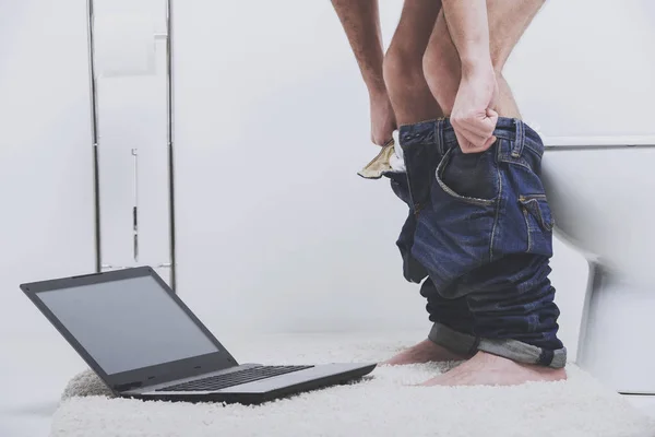 Zakenman werkt met laptop zittend op het toilet — Stockfoto