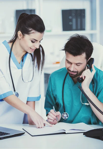 Il giovane medico e il suo assistente in uno studio medico al lavoro — Foto Stock