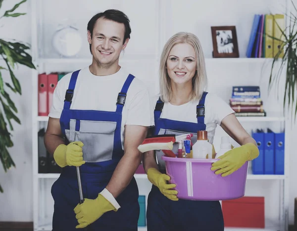 Jovem casal sorrindo estão segurando ferramentas de limpeza — Fotografia de Stock