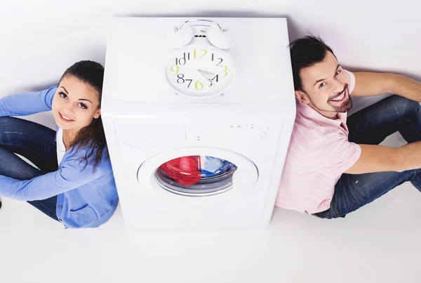 Jovem casal bonito com uma máquina de lavar roupa, no fundo branco. Vista superior — Fotografia de Stock