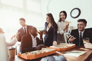 Ofis personeli pizza yemek ve kahve içmek iş ofiste.