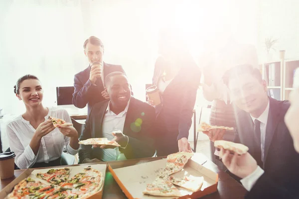 Kontorspersonalen äta pizza och dricka kaffe i verksamheten kontoret. — Stockfoto