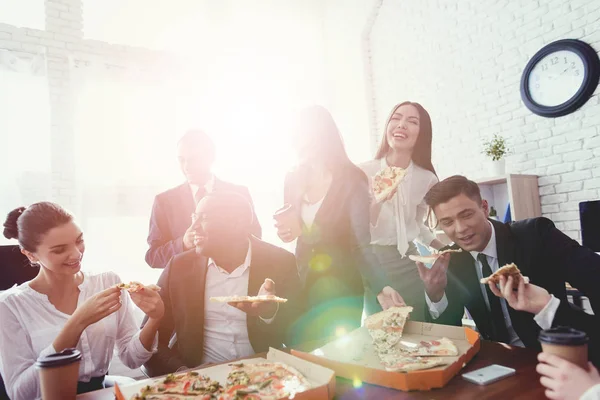 A equipe do escritório come pizza e bebe café no escritório de negócios . — Fotografia de Stock