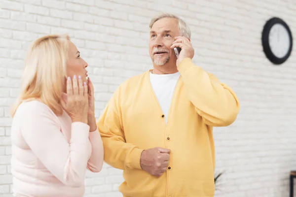 Человек Жёлтом Кардигане Разговаривает Телефону Женщина Розовом Свитере Стоит Рядом — стоковое фото