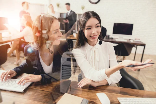 Las operadoras del centro de llamadas juntas miran la pantalla de la computadora . — Foto de Stock