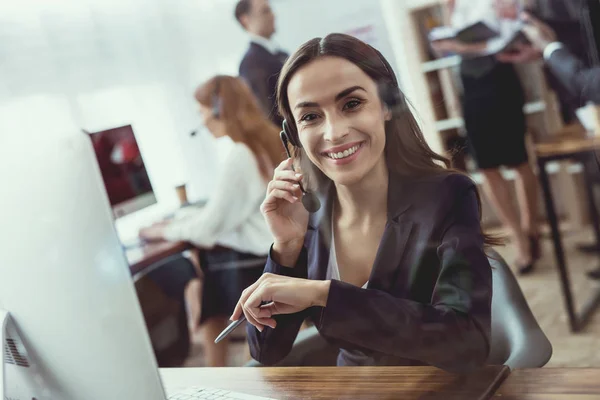 A menina morena está sentada no computador . — Fotografia de Stock