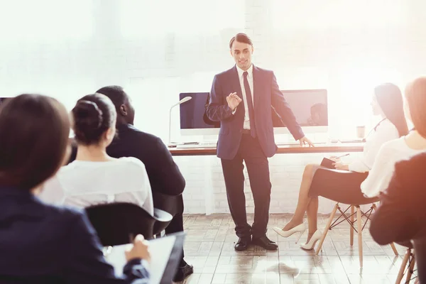 Un hombre de apariencia árabe está dando una conferencia para los empleados de oficina . — Foto de Stock