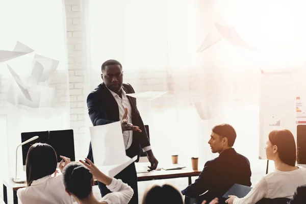 A black man talks to employees of a business office at a seminar. — Stock Photo, Image