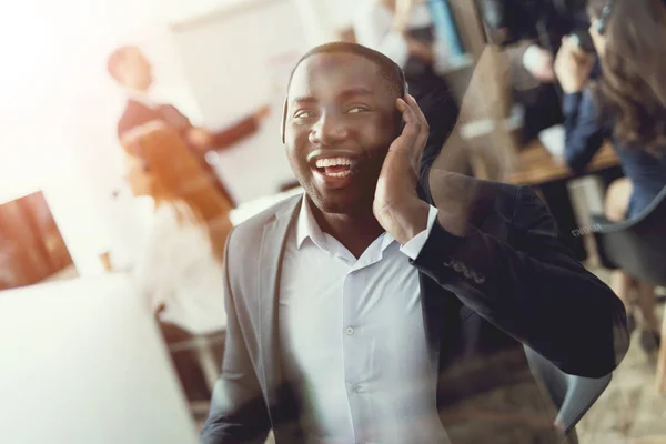 En svart kille fungerar som call center-operatör. — Stockfoto