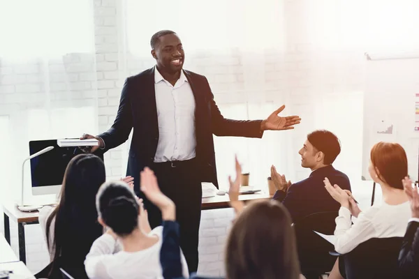 En svart man talar till anställda i ett företag kontor vid ett seminarium. — Stockfoto
