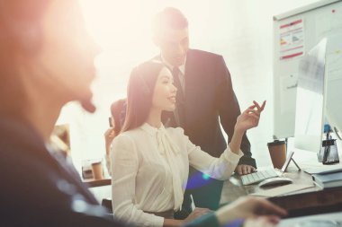 Kız operatör ve adam birlikte ofiste bilgisayar ekranında izliyor. Çağrı merkezinde çalışıyorlar. İyi bir ruh halinde oldukları.