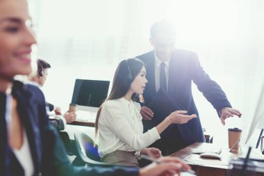 Kız operatör ve adam birlikte ofiste bilgisayar ekranında izliyor. Çağrı merkezinde çalışıyorlar. İyi bir ruh halinde oldukları.