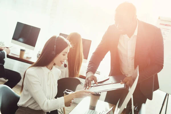 Eine Betreiberin und ein schwarzer Mann diskutieren etwas in ihrem Büro. — Stockfoto