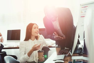 Kadın bir işleç ve bir siyah adam onların ofisinde bir şey görüşüyorlar.