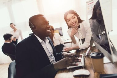 Bilgisayar ekranı ve gülüyor siyah çağrı merkezi operatörü görünüyor.