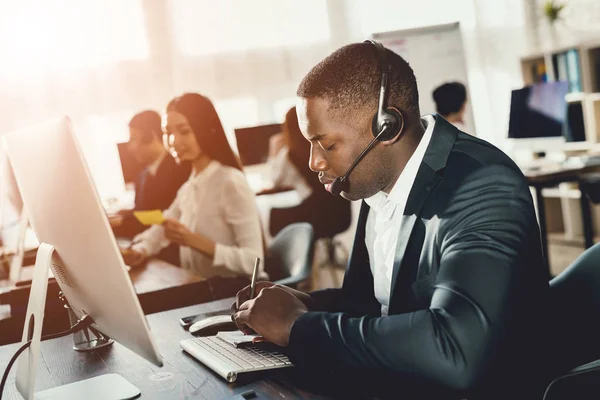 Negro Trabalha Num Call Center Ele Tem Fones Ouvido Nos — Fotografia de Stock