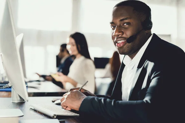 Czarny Facet Pracuje Call Center Słuchawki Które Oni Rozmawiać Klientami — Zdjęcie stockowe
