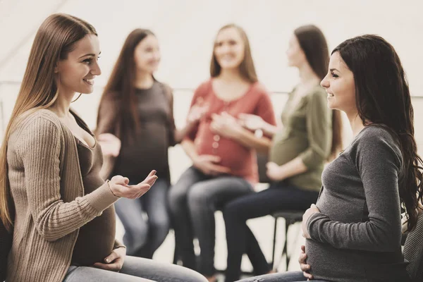 Las mujeres embarazadas felices están hablando juntas en la clase prenatal en el hospital —  Fotos de Stock