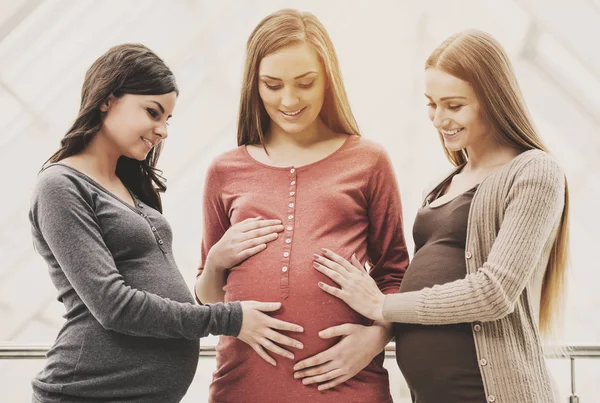 Baby dusch. Två glada kvinnor vidrör deras gravida vän mage — Stockfoto