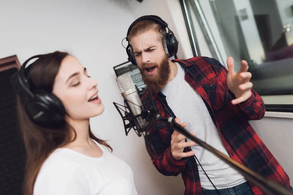 男と女は 現代のレコーディング スタジオで歌を歌います 男は女性の赤いチェックのシャツ シャツです — ストック写真