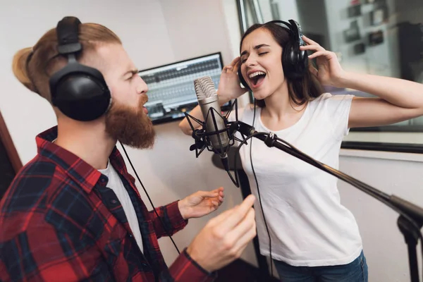 男と女は 現代のレコーディング スタジオで歌を歌います 男は女性の赤いチェックのシャツ シャツです — ストック写真