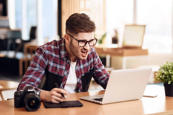 Freelancer człowiek sfrustrowany w laptopie siedząc przy biurku. — Zdjęcie stockowe