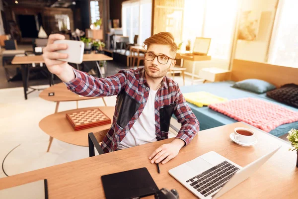 Freelancer hombre tomando selfie en portátil sentado en el escritorio . — Foto de Stock
