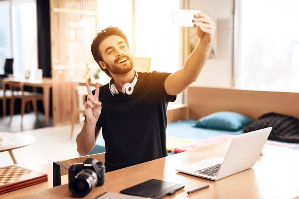 Freelancer Brodaty mężczyzna biorąc selfie w laptopie siedząc przy biurku. — Zdjęcie stockowe