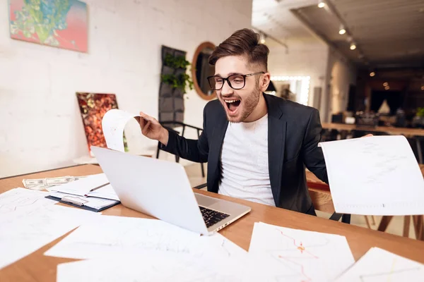 Freiberufler schaut glücklich auf Laptop am Schreibtisch. — Stockfoto