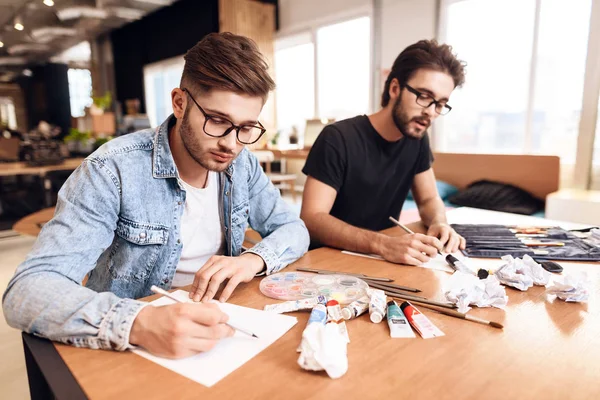 Dos hombres freelancer dibujando sobre papel con lápices en el escritorio . —  Fotos de Stock