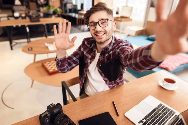 Freelancer człowiek biorąc selfie w laptopie siedząc przy biurku. — Zdjęcie stockowe