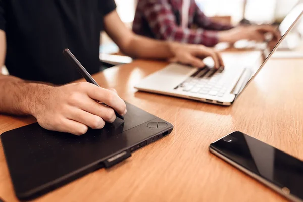 Feche dois homens freelancers trabalhando em laptops diferentes na mesa . — Fotografia de Stock